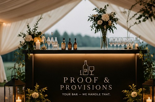 Proof & Provisions branded bar inside a candlelit reception tent
